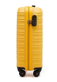 Jasně žlutý tvrdý kufr na kolečkách se čtyřmi černými kolečky a vestavěným číselným zámkem, který zajišťuje zipy.