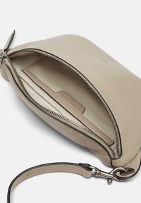 Beige Lederbeutel mit Reißverschluss und Handgelenkriemen. Das Innere verfügt über ein strukturiertes Futter und einen Kartensteckplatz. Dezente Markenkennzeichnung sichtbar.