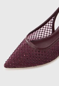 Teräväkärkinen viininpunainen verkkokorkokenkä, jossa on pieniä kiiltäviä strasseja ja kalaverkkokuvio sisävuorikankaassa.