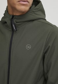Green hooded jacket with a front zipper and subtle logo detail on the chest. Made of smooth, lightweight material with a fitted design.