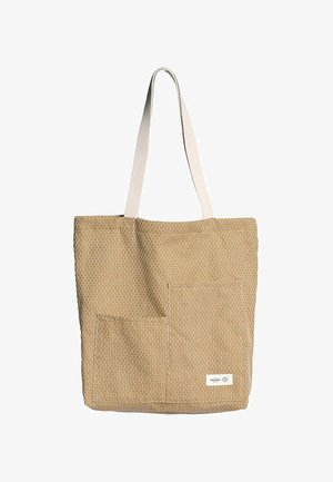 Geantă tote din pânză de culoare bej cu un model texturat; are două buzunare exterioare și o curea albă din pânză. Etichetă în colțul din dreapta jos.