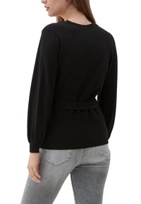 Schwarzer Pullover mit langen Ballonärmeln, einem taillierten Bund und einem gerippten Muster. Die Rückseite hat einen runden Halsausschnitt und eine figurbetonte Silhouette.