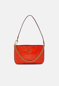 Czerwona torebka na ramię z teksturą krokodyla, z detalami w złotym kolorze i czarnym paskiem, z metalowym logo "GUESS EST 1981" z przodu.
