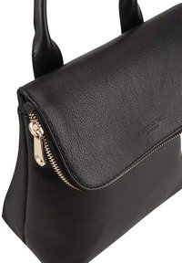 Zwarte leren handtas met een ritssluiting, zachte textuur en een slanke uitstraling. Voorzien van gouddkleurige hardware en een klepdeksel.