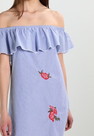 Abito a righe blu con spalle scoperte e scollatura a volant. Caratterizzato da ricami floreali rossi e una vestibilità comoda. Tessuto morbido.