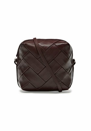 Kleine donkerbruine leren crossbodytas met geweven patroon en lange verstelbare riem op witte achtergrond.