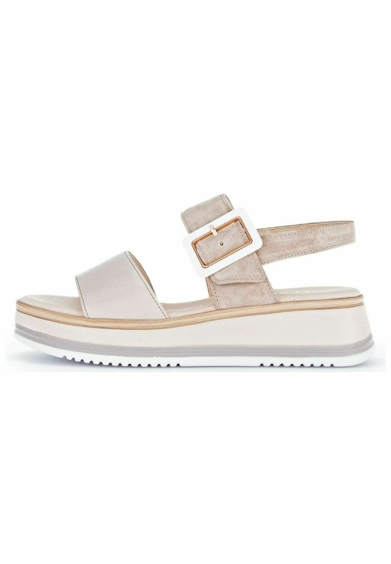 Beige wedge sandal featuring a smooth upper, a suede ankle strap with a rectangular white buckle, and a textured white outsole.