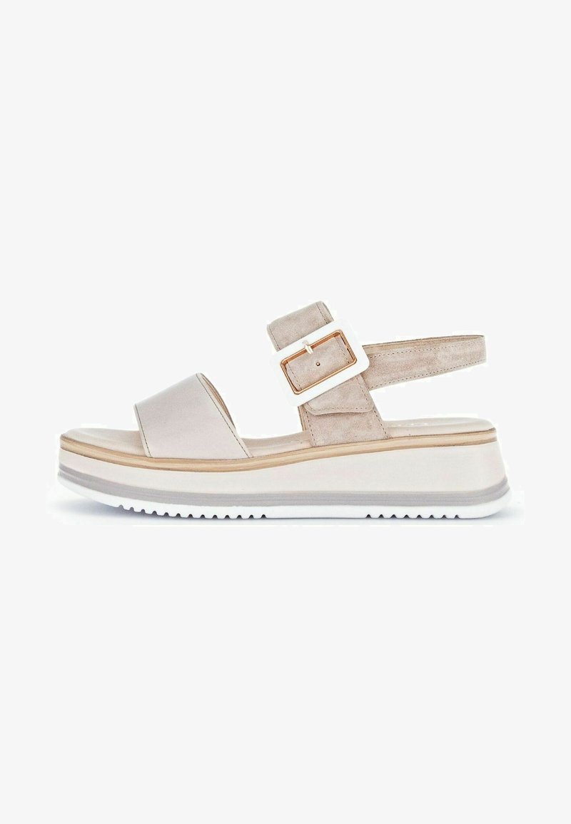 Beige wedge sandal featuring a smooth upper, a suede ankle strap with a rectangular white buckle, and a textured white outsole.