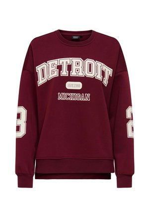Burgundijas krāsas džemperis ar balto tekstu "DETROIT" un "MICHIGAN". Iespējas: garas piedurknes, ribotās aproces un brīva piegriezuma siluets ar noapaļotu apakšmalu.