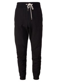 Schwarze Jogginghose aus weichem Stoff mit einem elastischen Bund, verstellbarem Kordelzug und schmal zulaufenden Beinen. Keine Taschen oder zusätzlichen Details.