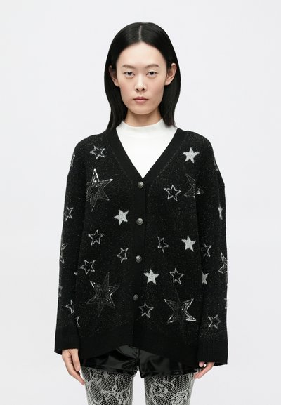 Schwarzer Cardigan mit silbernen und weißen Sternmustern, V-Ausschnitt, Knopfverschluss und weichem, strukturiertem Stoff.