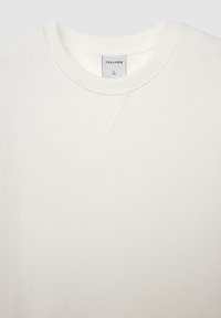 Sweatshirt beige clair en tissu doux avec col rond et surpiqûre en forme de V au niveau du col. L'étiquette indique "CALLIOPE" avec la taille L.