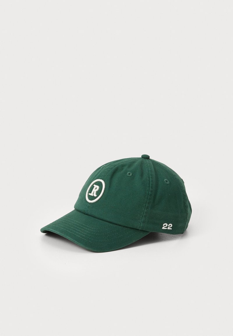 Green cotton cap with a rounded bill, featuring an embroidered "R" in a circle and the number "22" on the side. Textured fabric.