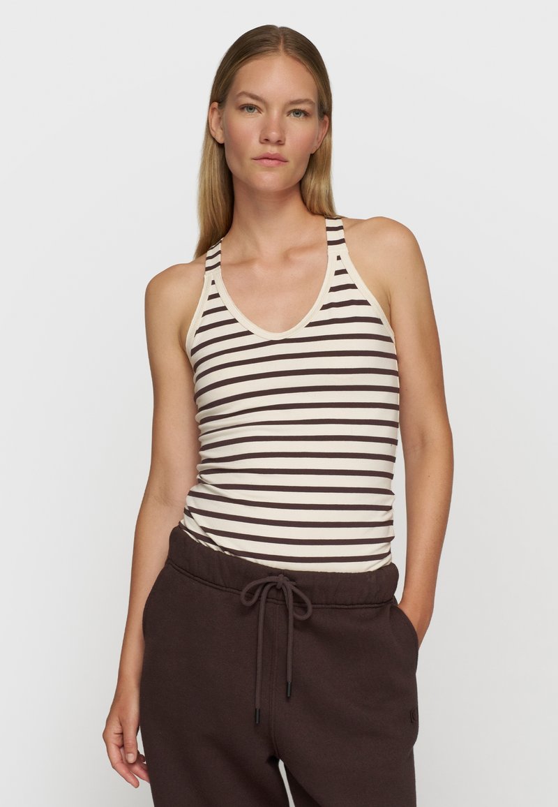 Stribet tanktop med en lys kremlignende bund og mørkebrune vandrette striber. Racerback-design, blødt bomulds materiale og en tætsiddende pasform.
