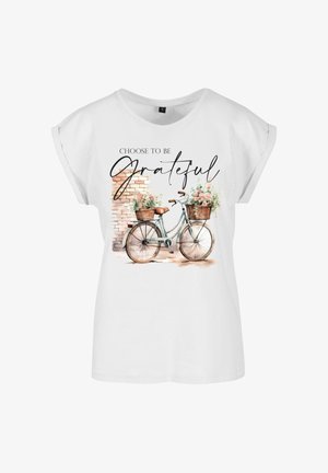Valge lühikeste varrukatega t-särk, millel on akvarellmaal jalgrattast lillekorvidega ja tekst "Vali olla Tänulik."