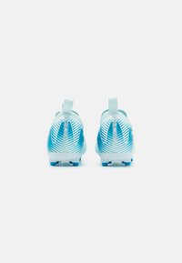 Botas de fútbol azul claro con un upper texturizado, que presentan rayas horizontales blancas y una pestaña en el talón para ponerlas y quitarlas fácilmente. Suela con tacos para tracción.