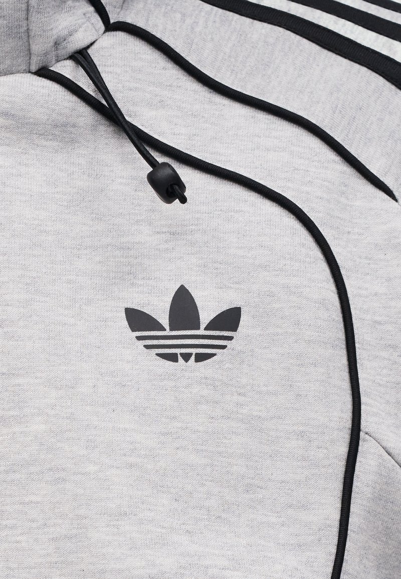 Lichtgrijze hoodie met zwart Adidas trefoil-logo, zwarte trekkoorden met een plastic stopper en zwarte strepen langs de schoudernaad.