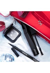KIKO sminkeprodukter på en lys bakgrunn: en sølvøyenskygge, svart mascara og eyeliner, sammen med en rød glidelåsveske med en skinnende logo.