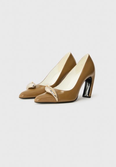 Chaussures à talons hauts en cuir verni marron avec un bout pointu, arborant un accent métallique sur l'empeigne et un talon noir brillant.