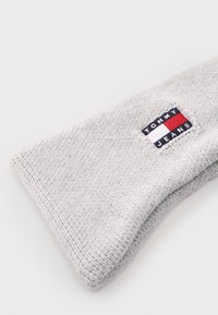 Hallide hallitusest kudumiga beanie, millel on tekstuurne muster ja väike ristküliku kuju sinine, punane ja valge логотипi sildiga, millel on kirjas "TOMMY JEANS."