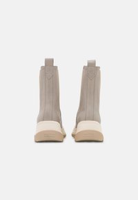 Beige Stiefeletten mit einem Obermaterial aus glattem Leder, elastischen seitlichen Einsätzen und einer strukturierten Gummisohle. Mit Logodetail auf der Rückseite.