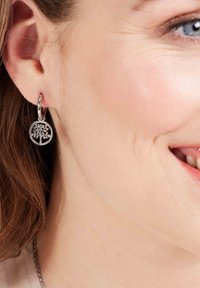 Zilveren hoepel oorbellen met een ronde hanger met een boomontwerp, dat fijne uitgesneden details en een gepolijste afwerking toont.