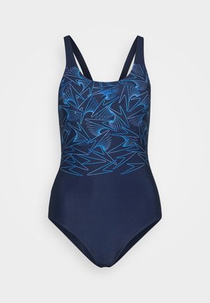 Donkerblauwe badpak met een lichtblauw abstract vogel- en zigzagpatroon op de bovenkant, met dunne schouderbandjes.