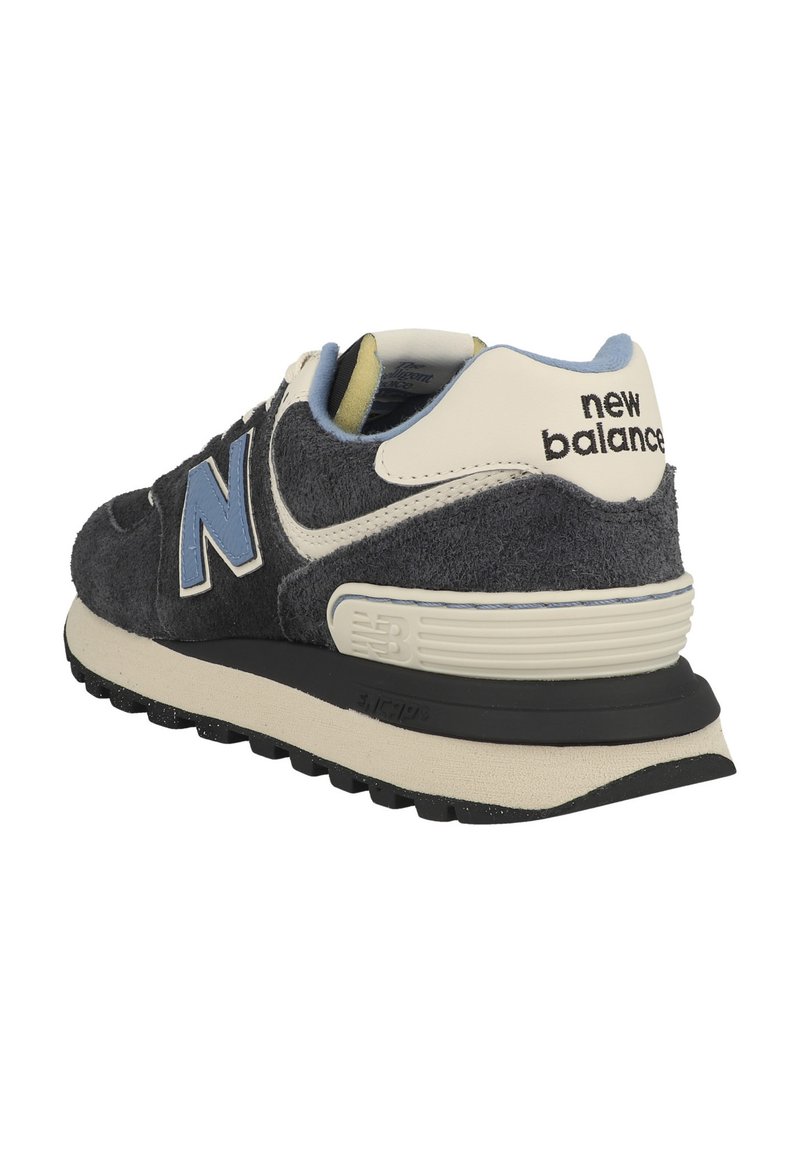 Baskets en suède noir et gris avec un logo "N" bleu, des accents crème, un col rembourré et une semelle en caoutchouc noir avec une texture antidérapante.
