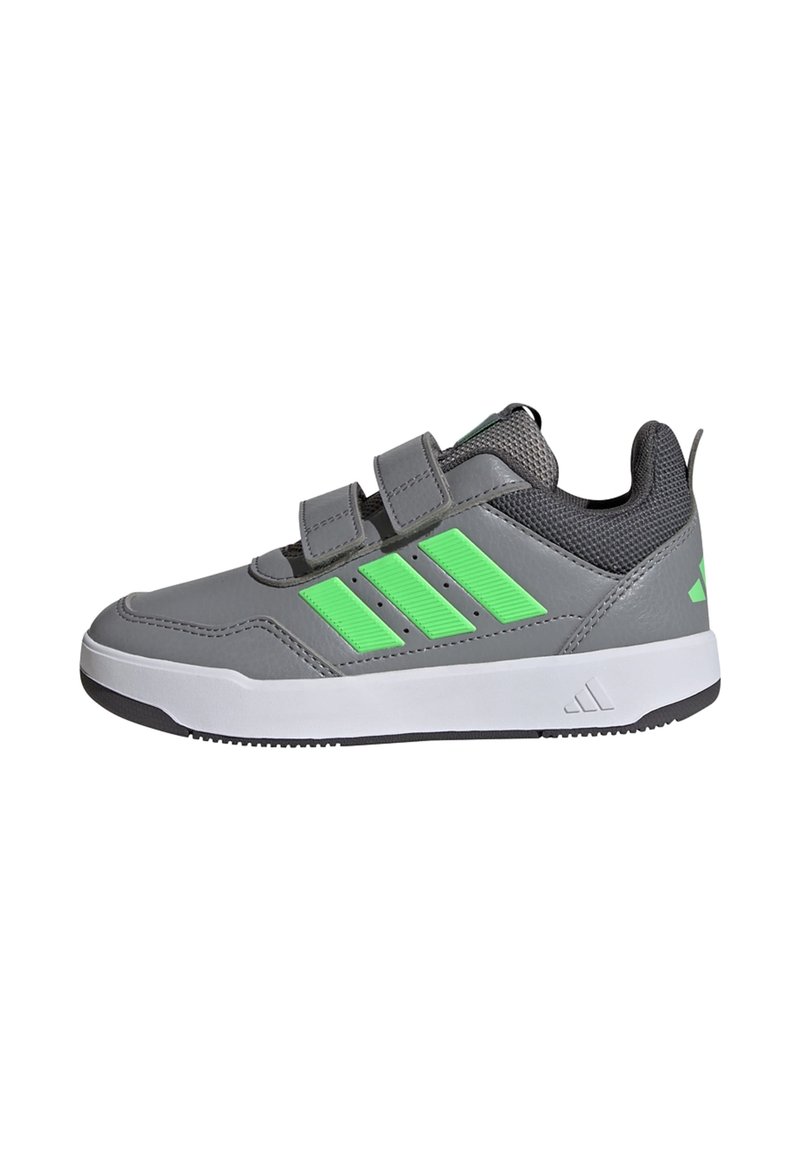 Zapatilla deportiva gris con acentos verdes, parte superior de malla texturizada, suela plana y dos correas de velcro para un cierre seguro.