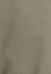 Tissu en coton d'un olive atténué avec une fine texture côtelée diagonale, présentant une finition lisse et mate.