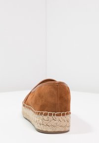 Brune ruskind espadrille med en flettet jute-sål, der har en rund bag og syet detalje langs kanten. Glatte læderaccenter på overdelen.