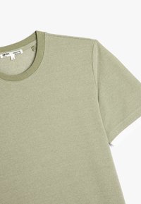 Lys grøn kortærmet t-shirt i et struktureret, bomuldsstof med rund hals. Simpelt design, ingen synlige mønstre eller detaljer.