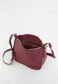 Bolso de mano de cuero burdeos con un acabado texturizado, strap ajustable y cierre con cremallera en la parte superior. Se puede ver un bolsillo interior para almacenamiento.