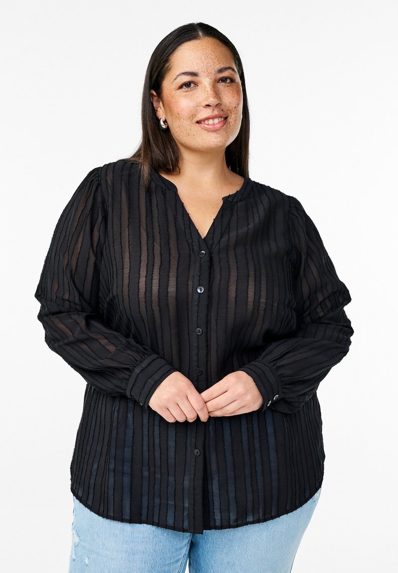 Schwarze Bluse mit Knopfleiste, vertikalen Strukturstreifen, langen Ärmeln und einem weichen Kragen. Das Material wirkt leicht und semi-transparent.