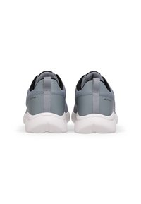 Bakvy av lätta sneakers med en grå ovandel, texturerat läder och mesh-material, samt vit gummisula. Utrustad med dragflik och logotypdetaljer.