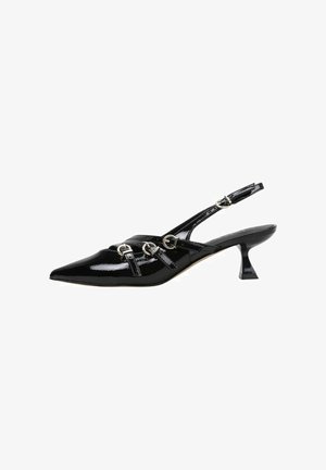 Zapato de tacón bajo tipo kitten de charol negro con tiras cruzadas en la parte delantera y tres hebillas plateadas.