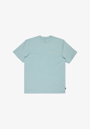 Jasnoniebieska koszulka z krótkim rękawem, z małym, zakrzywionym logo "Billabong" w beżowym kolorze na lewej piersi oraz czarną metką na dolnym bocznym szwie.