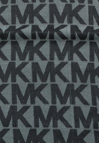 Tissu présentant un motif répétitif du logo noir "MK" sur un fond gris texturé, avec des détails de tissage diagonaux.