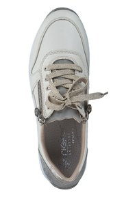 Light beige sneaker with textured leather, rounded toe, and lace-up design. Features a side zipper and a cushioned insole with perforations.