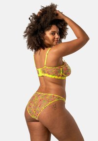 Genomskinlig blommig spets-bh och matchande trosor med guldkant, med färgglada blommönster och justerbara band.