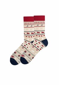 Beżowe skarpetki z czerwonymi i granatowymi akcentami, zdobione świątecznymi wzorami z reniferami, sercami i ciężarówkami, utworzone z teksturowanej tkaniny.