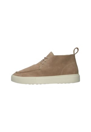 Botas de tobillo de ante beige con puntera redondeada y diseño de cordones. Suela de goma color crema y una pestaña en el talón.