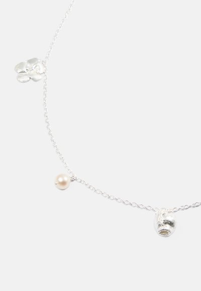 Ασημένια αλυσίδα με κρεμαστό λουλούδι, μικρό μαργαριτάρι και στρογγυλή ασημένια χάντρα, αναδεικνύοντας διάφορες υφές και φινιρίσματα.