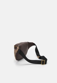 Brun tygmidjeväsk med en beige mönstrad accent, gulddragkedja och justerbar svart rem. Slät textur och en elegant, avsmalnande form.