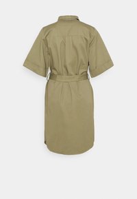 Robe vert olive avec des manches courtes, un col et une ceinture à nouer à la taille. Présente un dos plissé et un ourlet arrondi. Texture de tissu lisse.