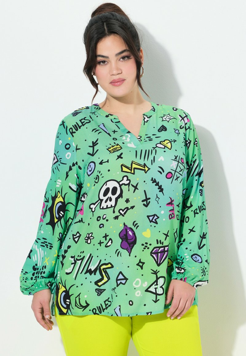 Grüne Langarmbluse mit V-Ausschnitt, ausgestattet mit einem verspielten Grafikdruck von Symbolen und Kritzeleien in Schwarz, Gelb und Pink. Glattes Material.