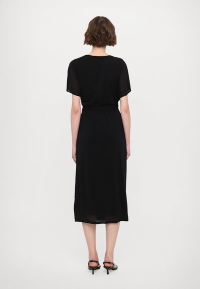 Vestido negro midi con mangas cortas y un corte relajado, que presenta una textura suave y un acento de cintura ceñida con cinturón.