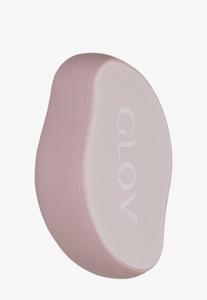 Tampon nettoyant en silicone rose avec une surface lisse blanche affichant "GLOV". Présente une forme ergonomique pour une prise en main facile.
