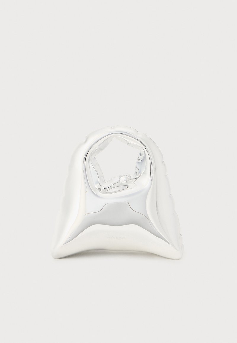 Zilveren metalen ring met een gladde, gepolijste oppervlakte, voorzien van een bloemenachtig ontwerp en een stervormige opening in het midden.