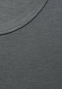 Tessuto jersey grigio con una trama liscia e un collo rotondo, caratterizzato da un orlo cucito con cura e un motivo sottile e uniforme in tutto il tessuto.